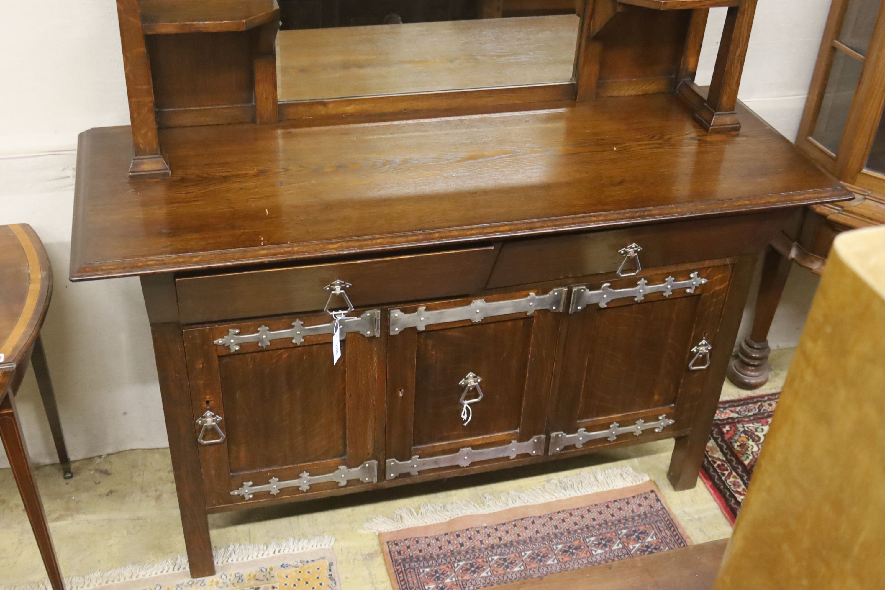 An early 20th century Arts & Crafts oak and polished steel mirrored sideboard, in the manner of Liberty & Co., length 152cm, depth 56cm, height 184cm